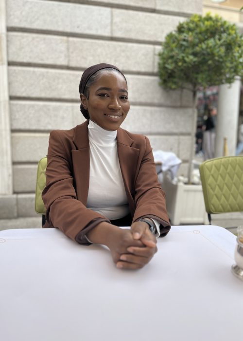 Rebeccah Onabajo, the digital marketing specialist, sitting in a restaurant and smiling.