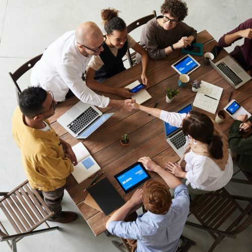 digital marketing roles Eight professionals in digital marketing careers gathered around a table.